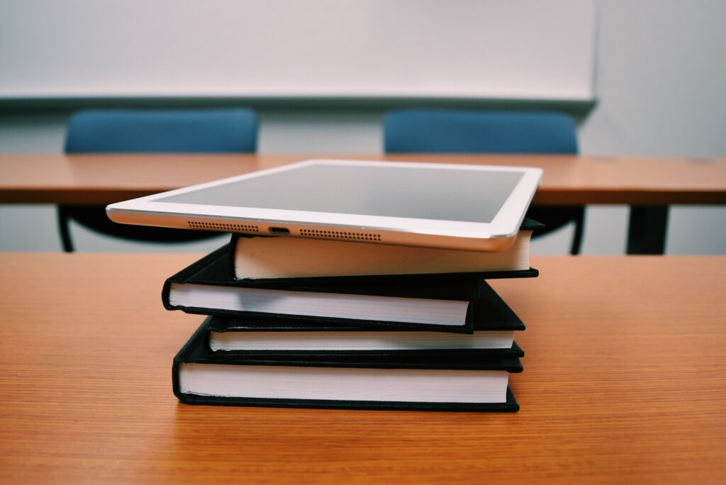 tablet y libros apilados sobre mesa