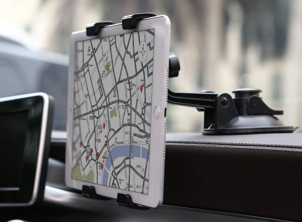 Automóvil guiado por GPS en una tablet suspendida por soporte para tablets apoyada en el salpicadero
