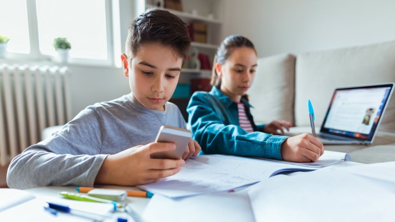 jovenes usando móvil en clase