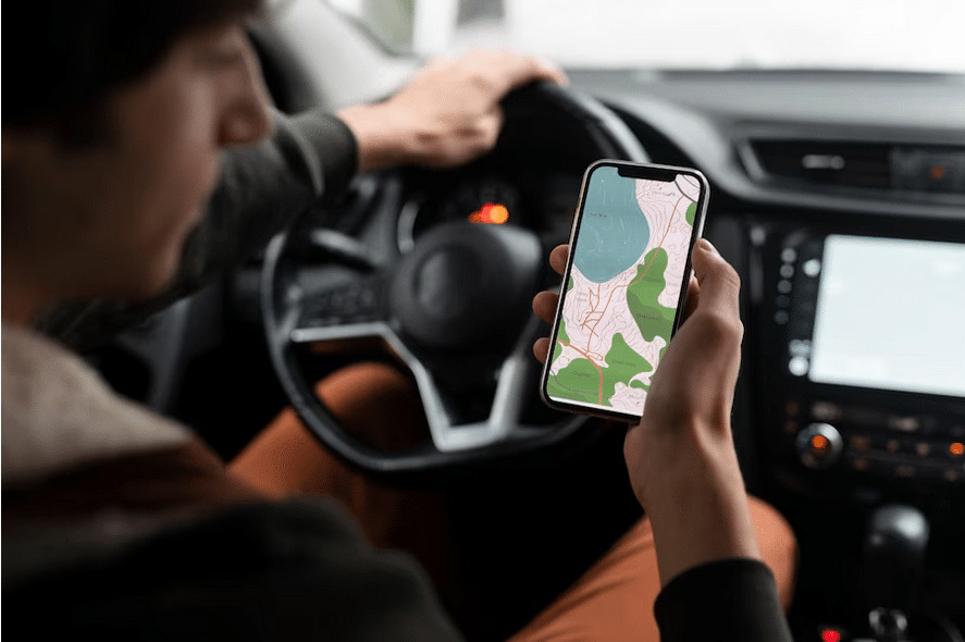 Persona maneja un automóvil mientras usa GPS de teléfono móvil