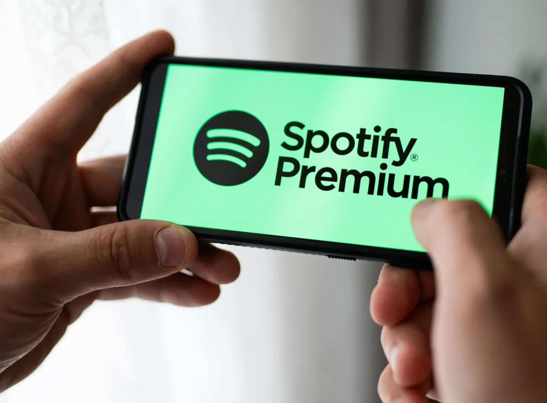 Hombre mira móvil para hackear spotify premium