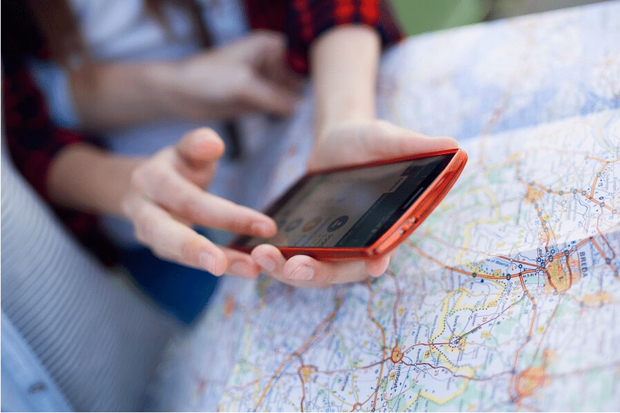 Dos personas usan un localizador de móviles Android frente a un mapa