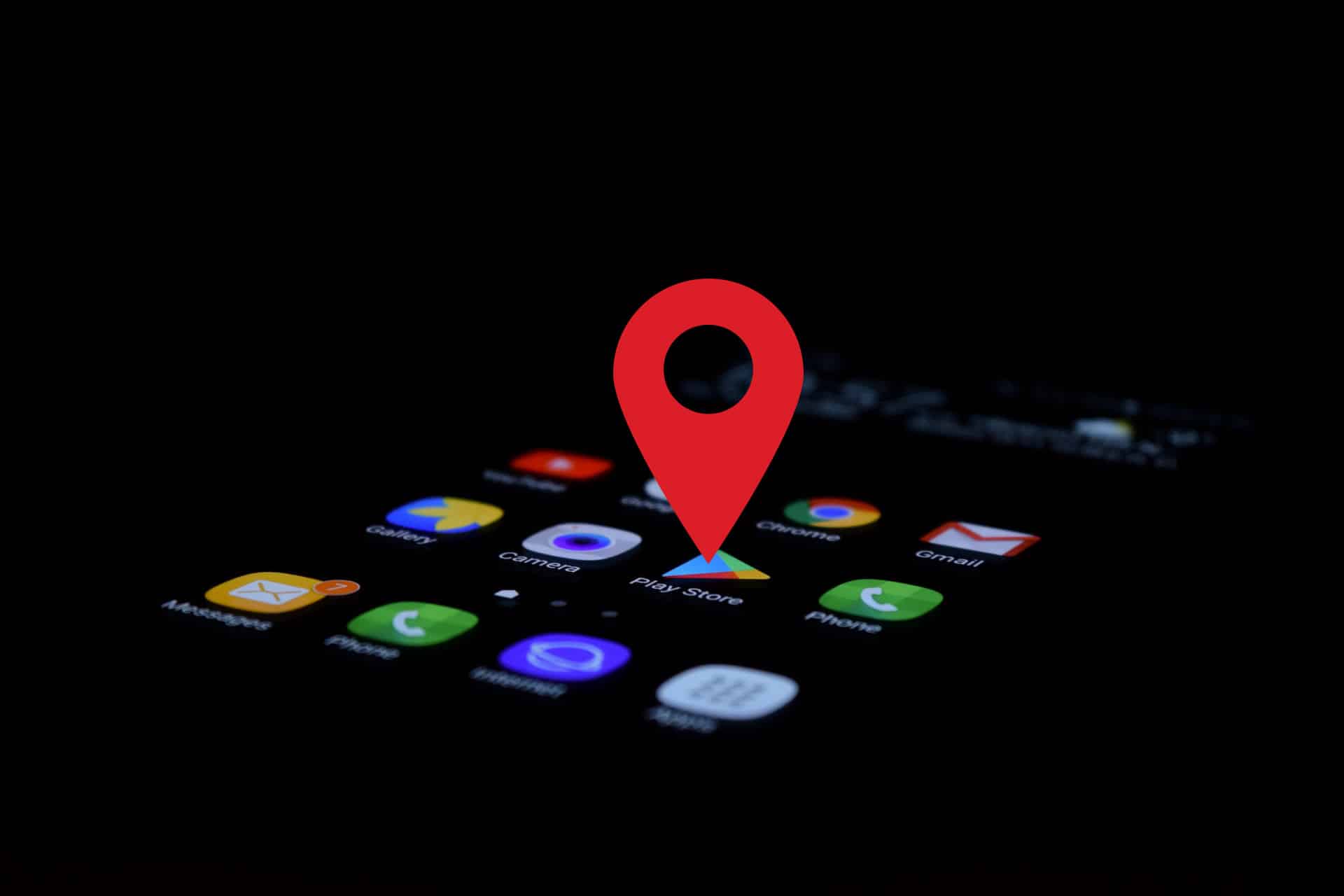 teléfono móvil en la oscuridad con la pantalla encendida y uel símobolo de ubicacón encima de la aplicación Google Play